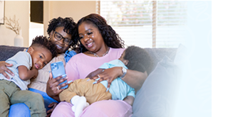 Image of a multi-generational family sitting together looking at a cell phone